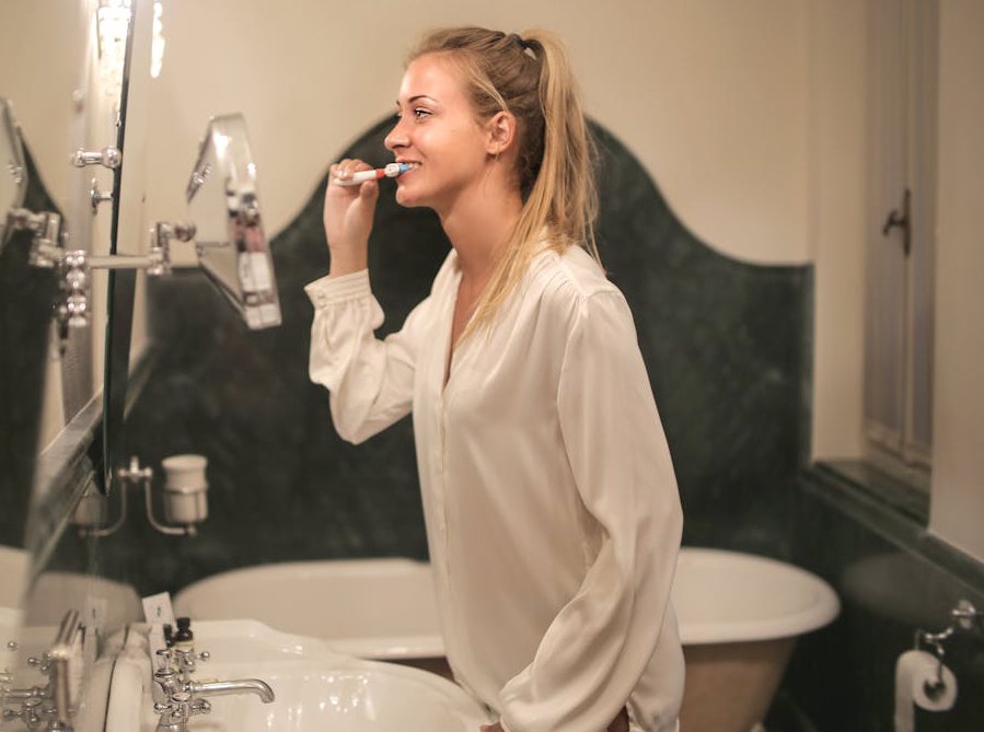 Young woman cleaning her teeth in bathroom
