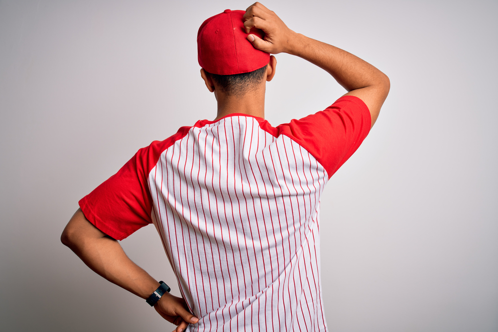 Sportsman wearing striped baseball t-shirt and cap Backwards
