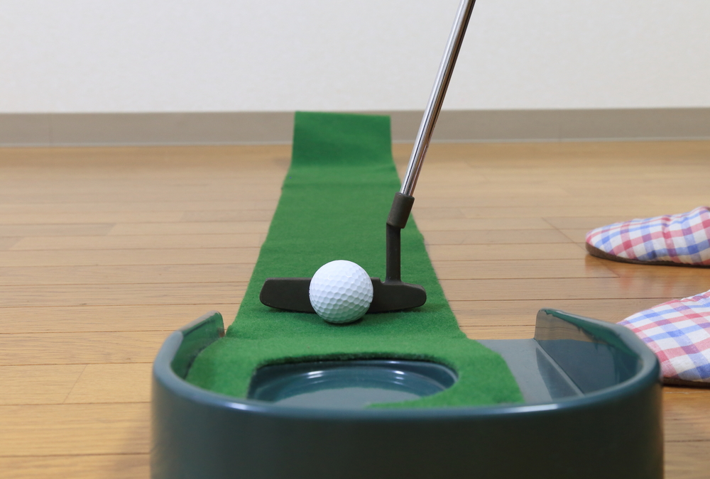Mini indoor golf toy placed on a wooden floor