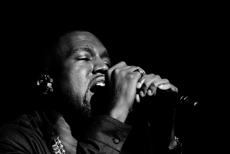 Kanye West singing on a microphone