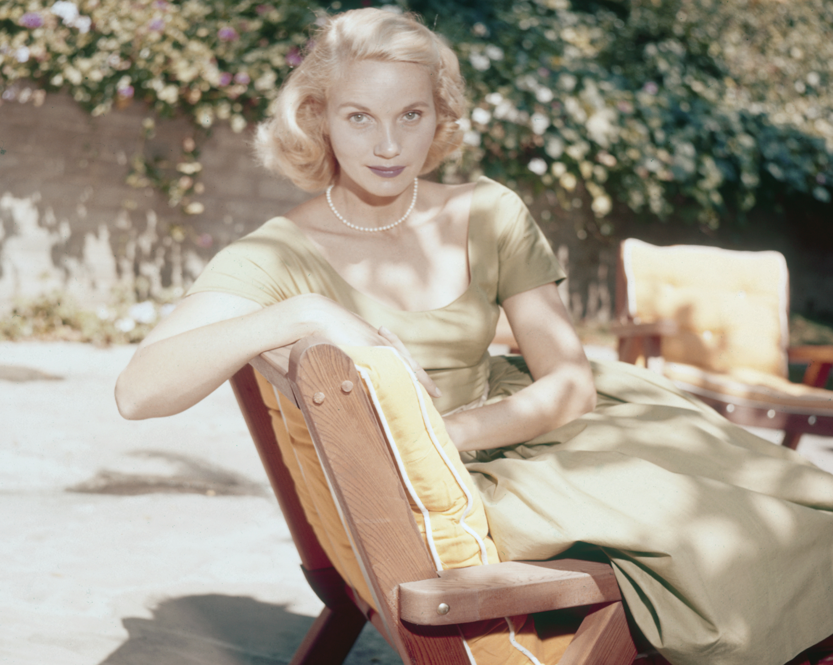 Actress Eva Marie Saint pictured seated on a sun lounger in a garden