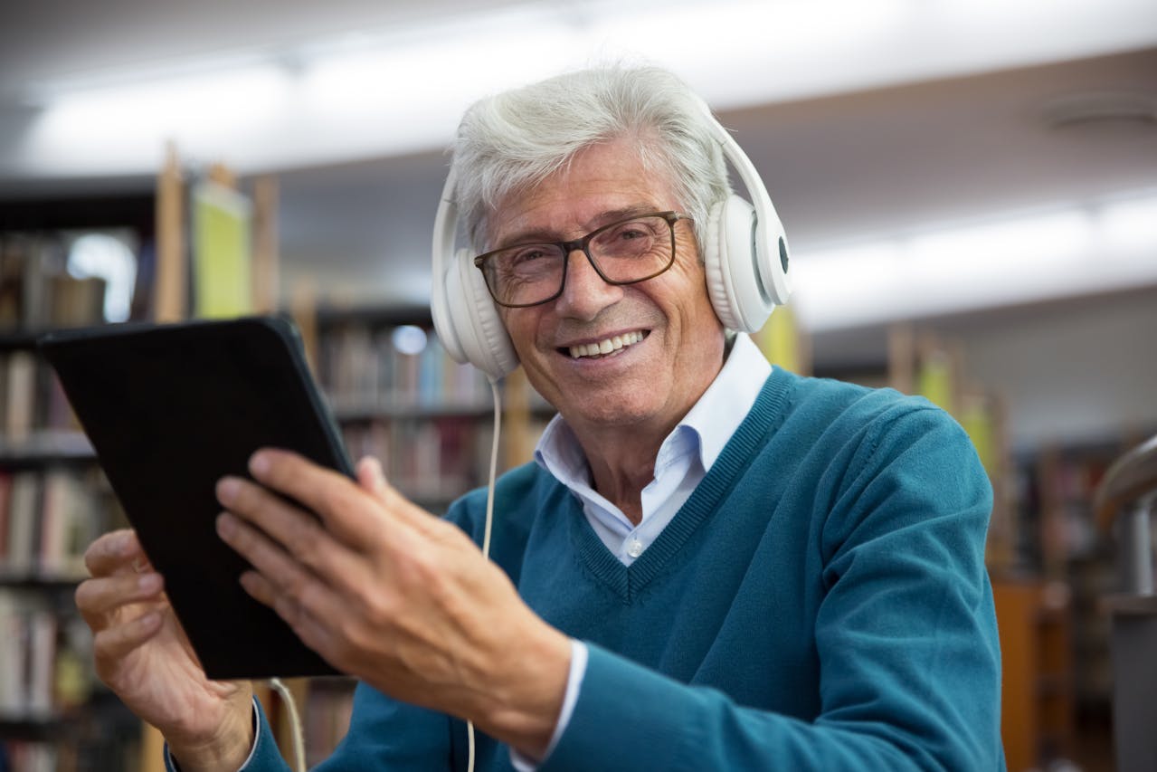 A Man in a Blue Sweater Using Headphones