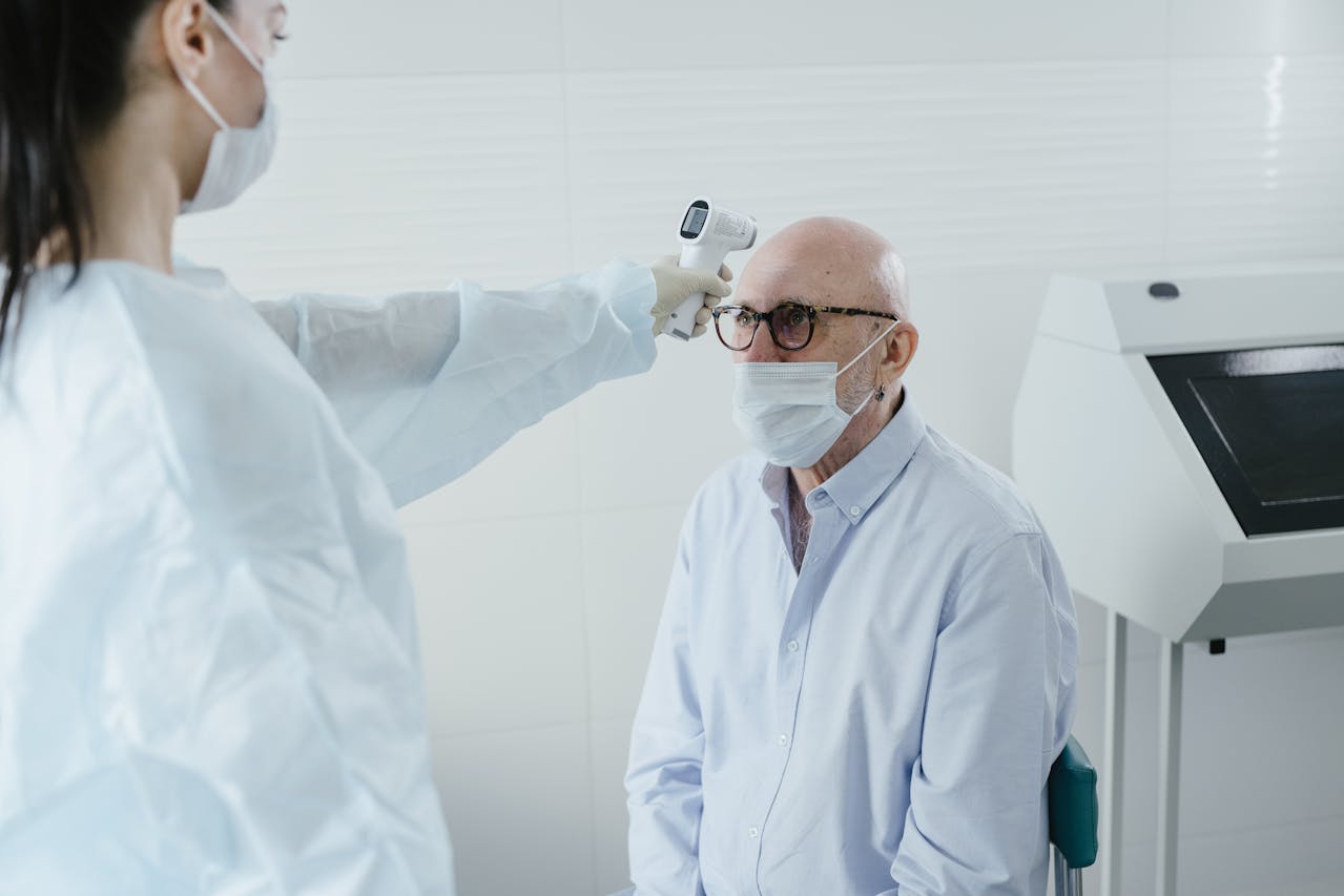 A Medical Professional Taking the Temperature of a Patient