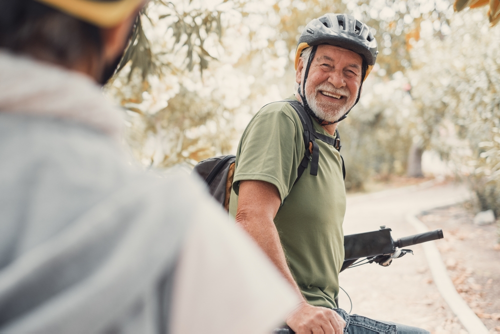 Two happy old mature people enjoying and riding bikes