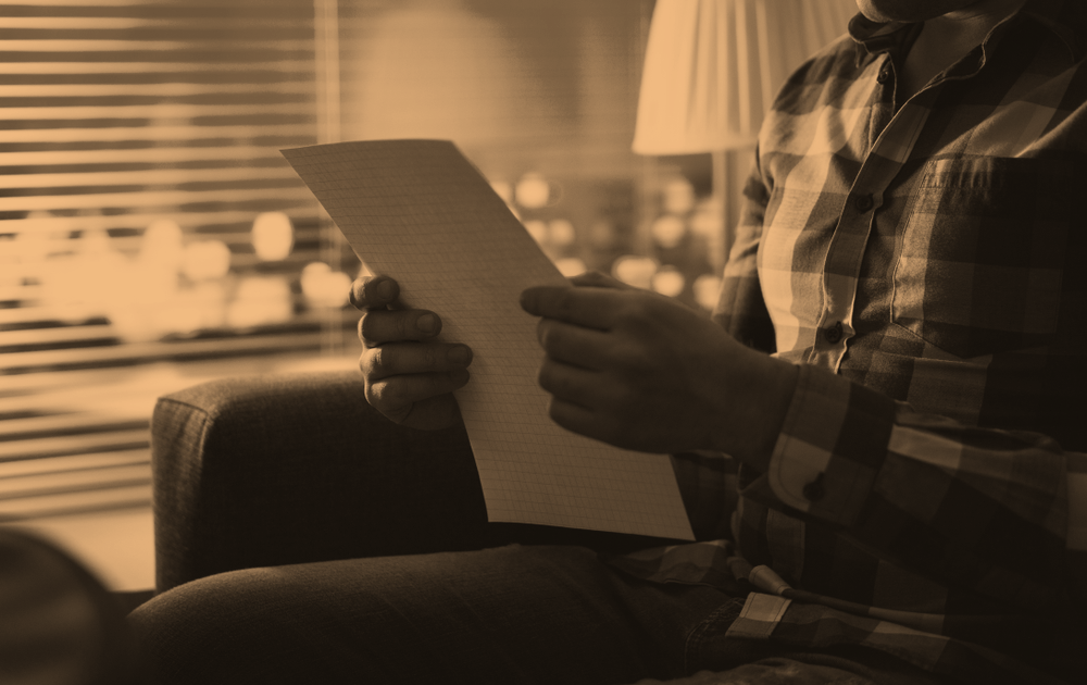 Man reading letter in dark at night