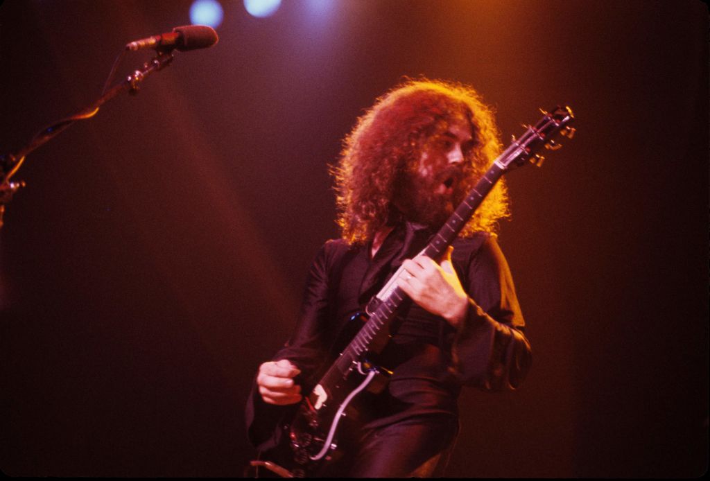 Photo of Brad Delp performing in black outfit