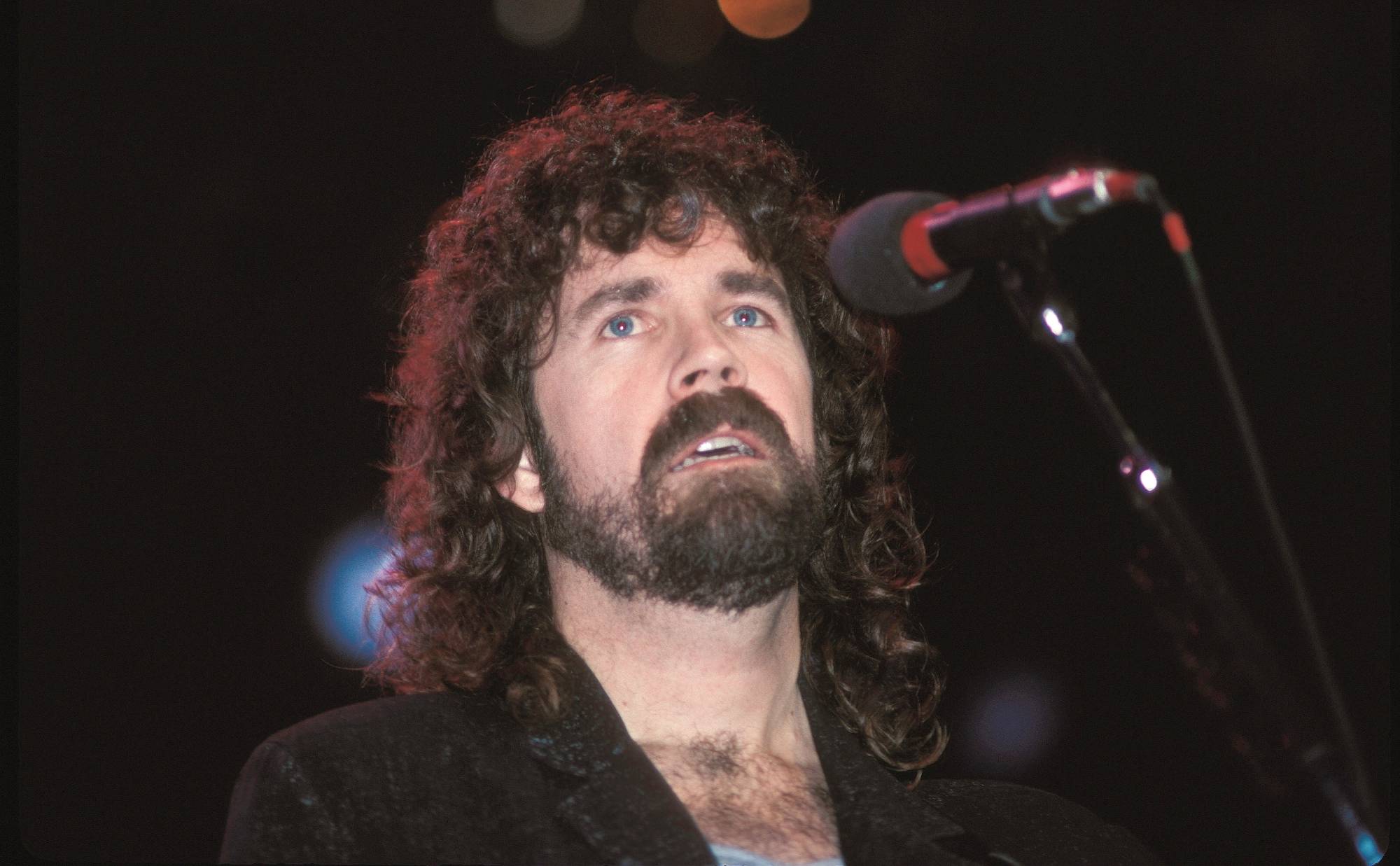 Singer Brad Delp is shown performing on stage