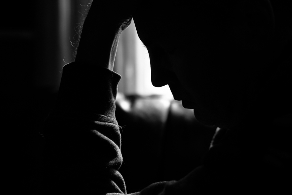 Monochrome photo of a depressed man silhouetted