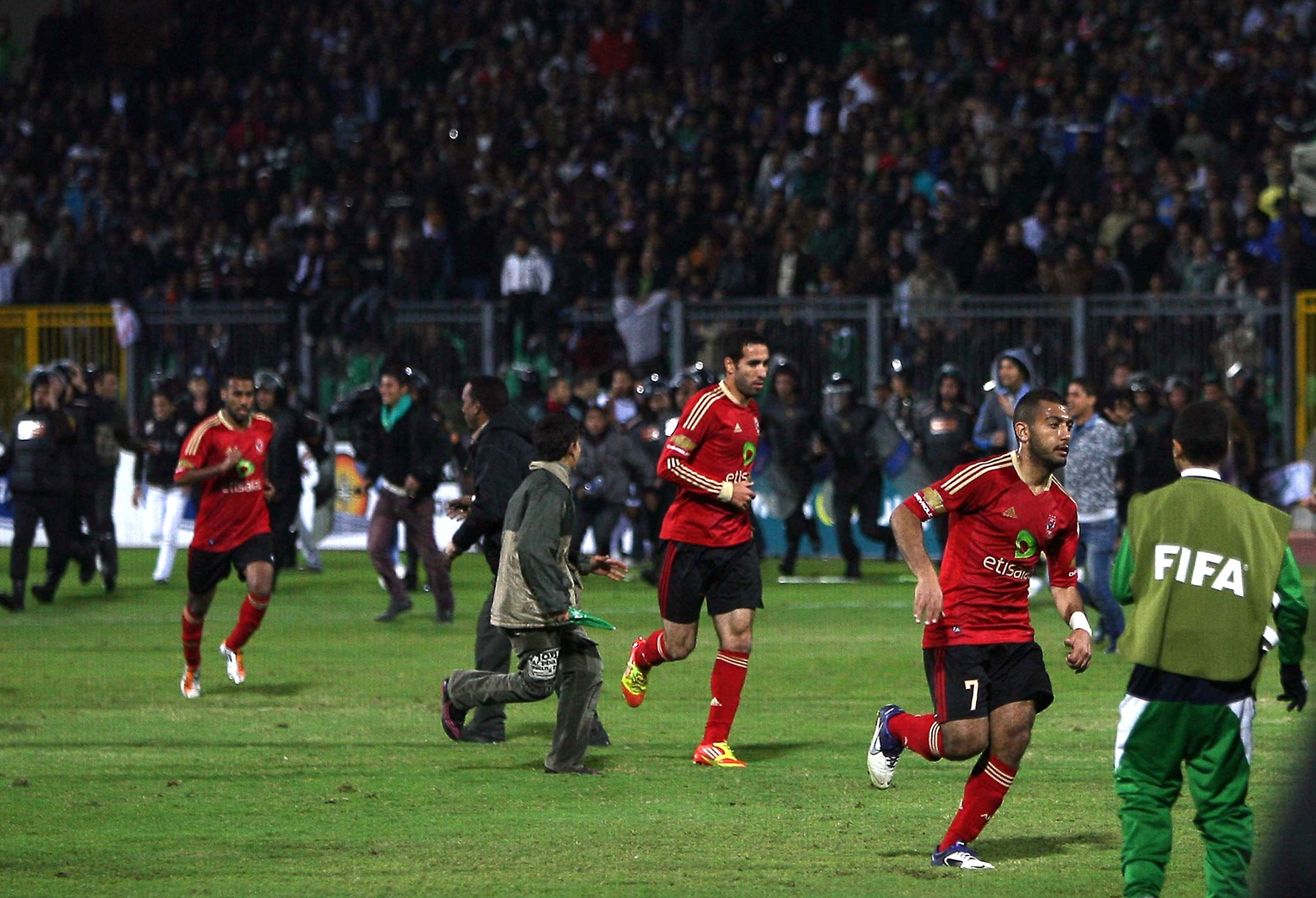 Egypt's Al-Ahly football players run away from clashes between rival football fans after their football match against Al-Masry in Port Said on February 1, 2012.