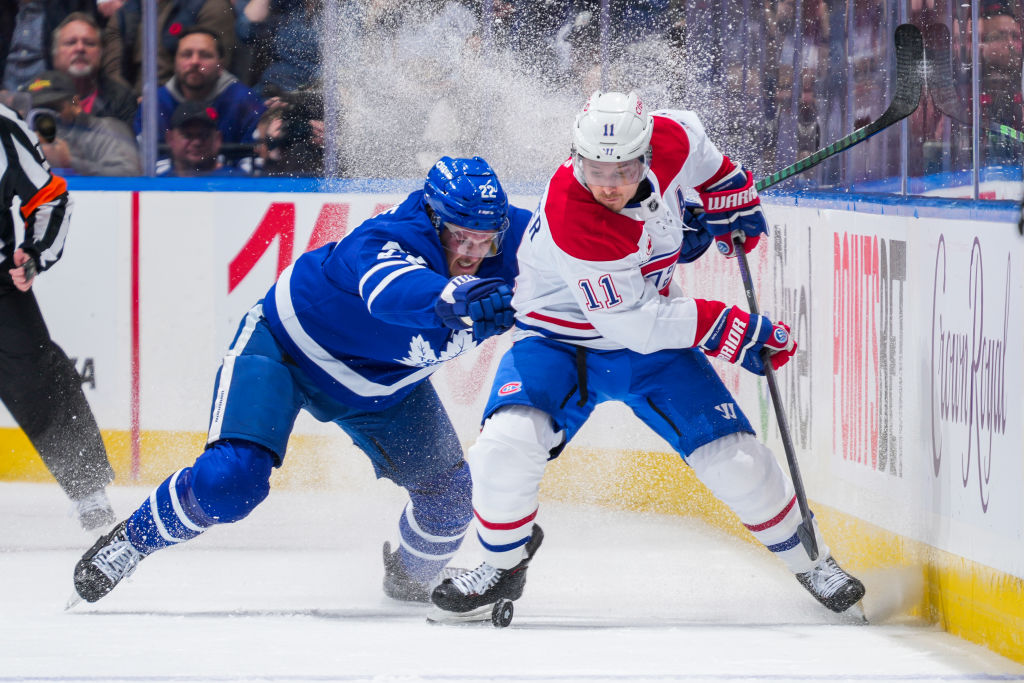 Jake McCabe #22 of the Toronto Maple Leafs battles for the puck against Brendan Gallagher #11 of the Montreal Canadien
