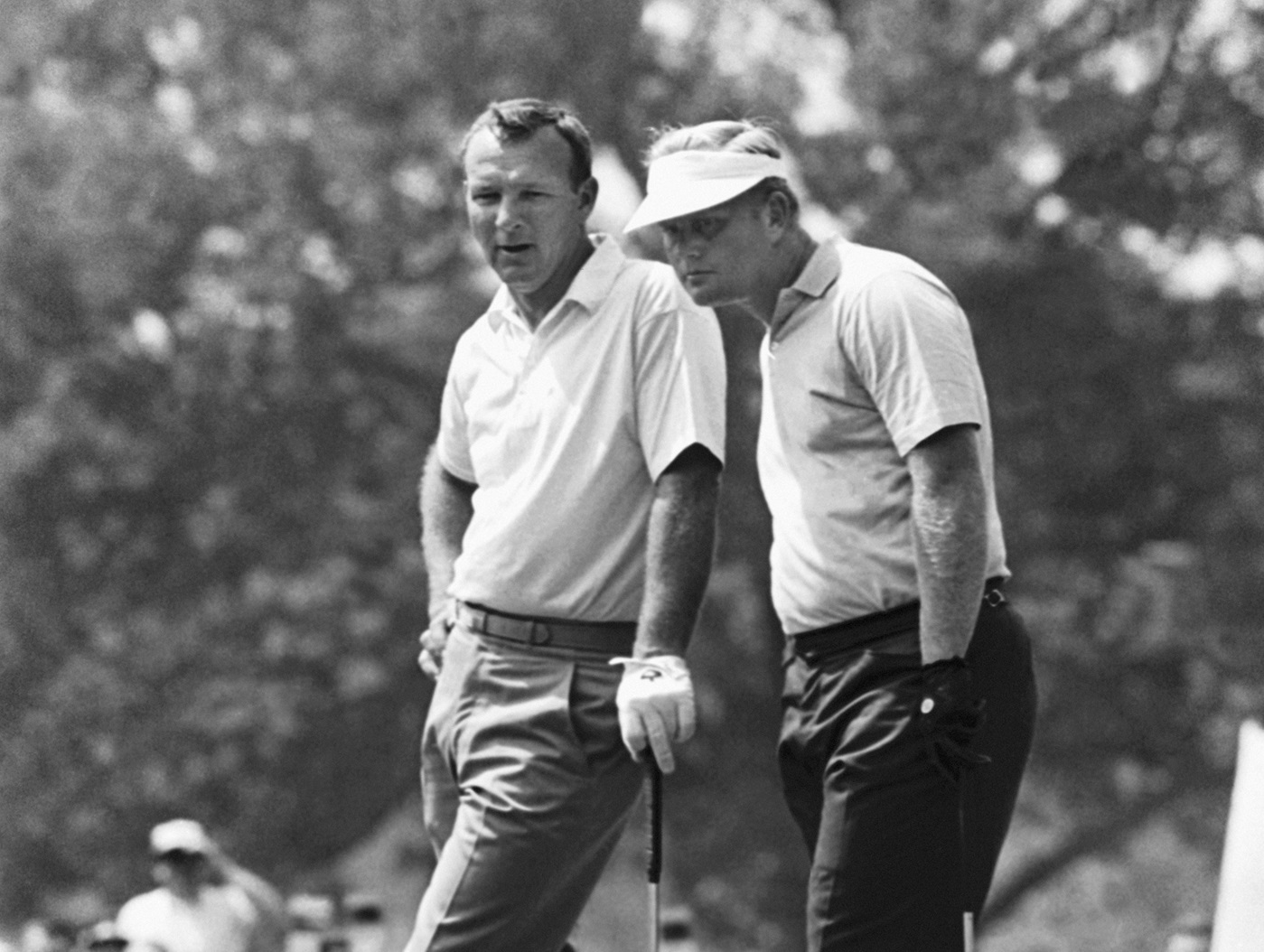 Arnold Palmer (left) leans on his putter and waits as Jack Nicklaus lines up - 1967