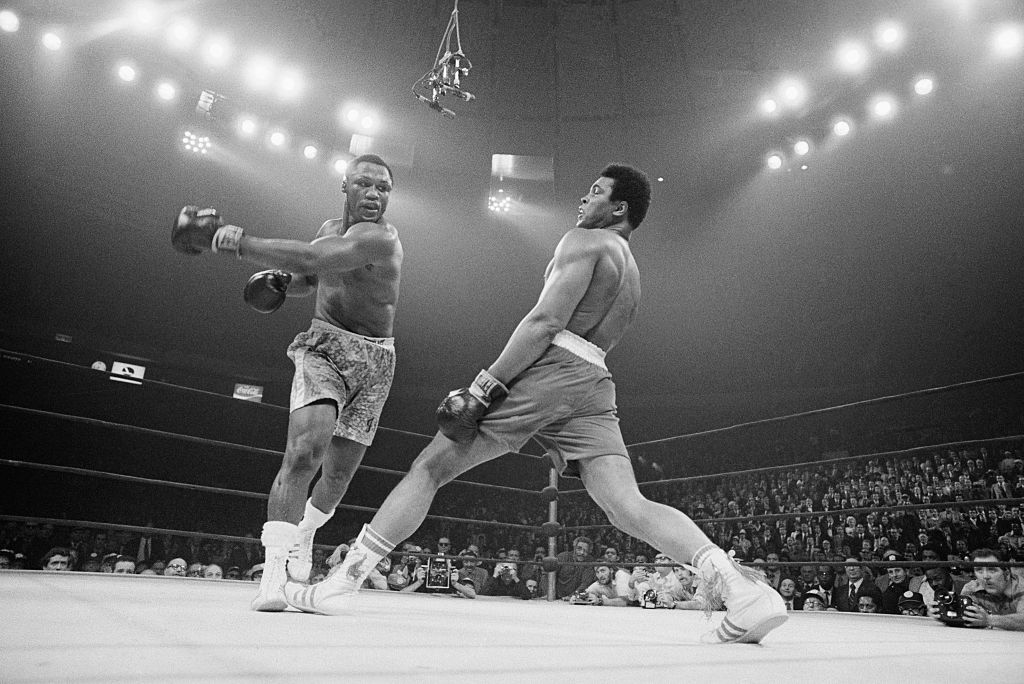 Boxer Muhammad Ali steps away from a punch thrown by boxer Joe Frazier