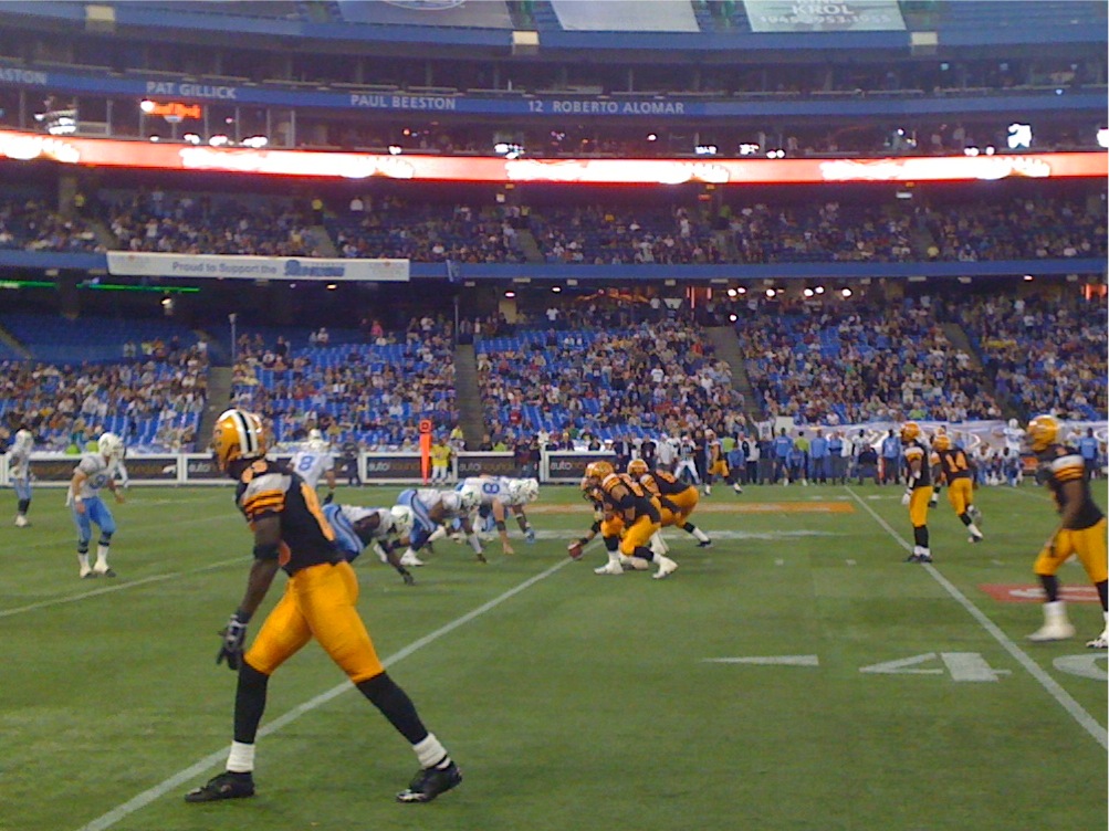 Hamilton Tiger-Cats (in black and gold) prepare to snap the ball on offence as the Toronto Argonauts