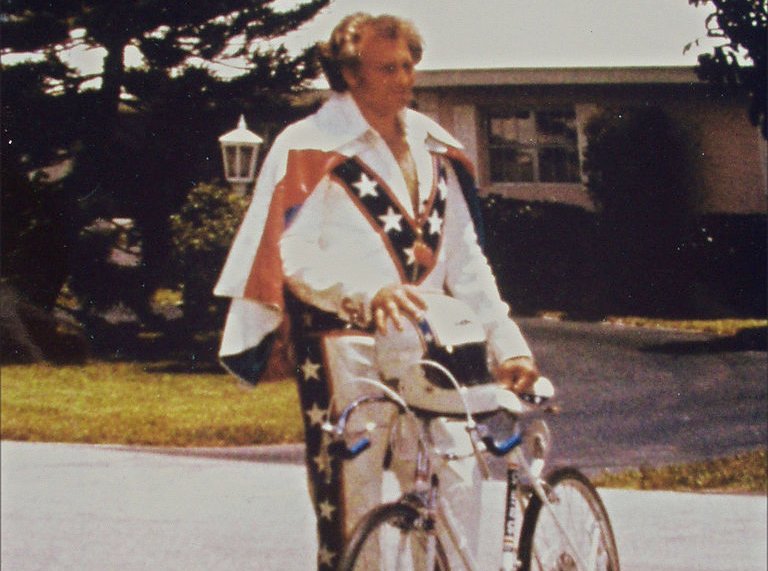 Evel Knievel with his bike wearing a white costume