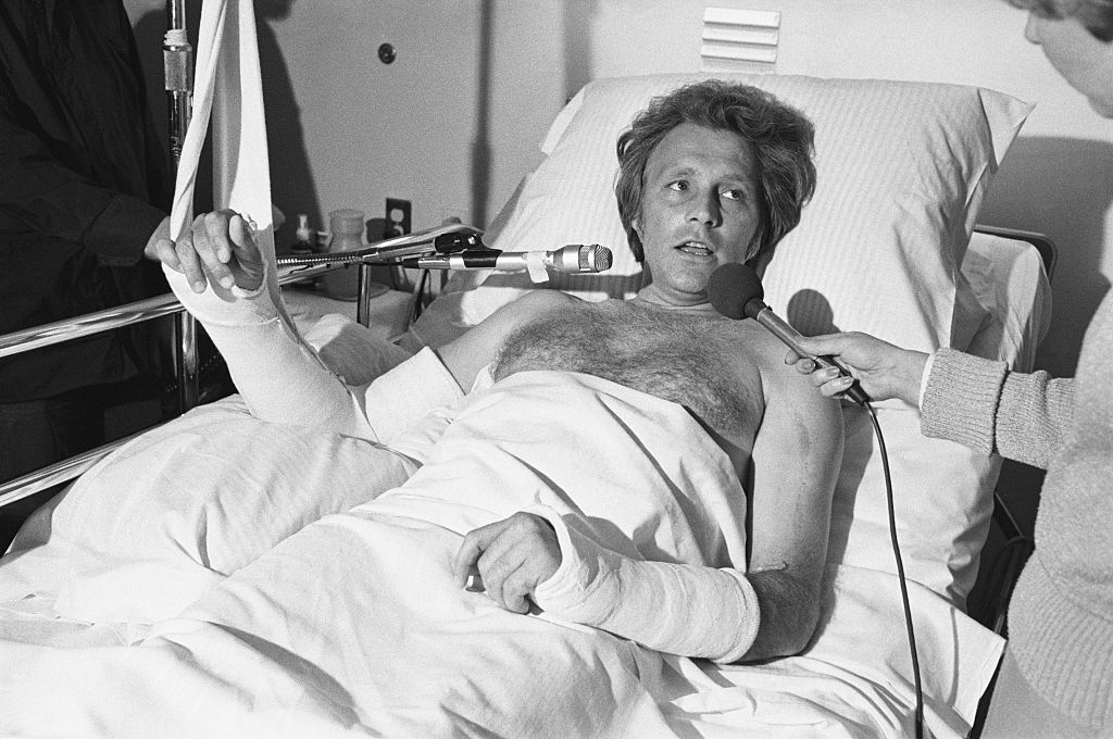 Stunt performer Evel Knievel gives interviews from his hospital bed