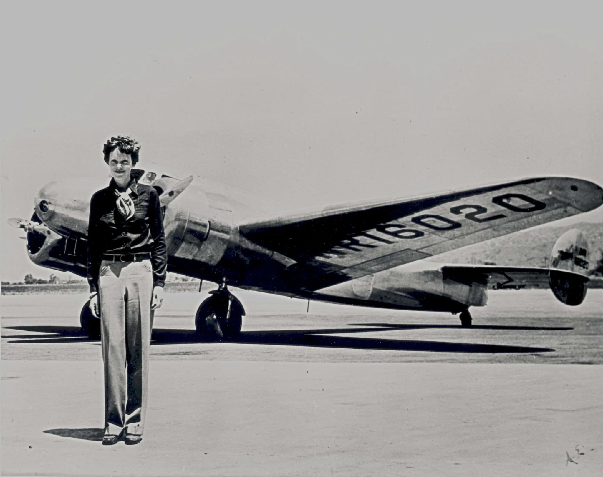 Amelia Earhart standing in front of the Lockheed Electra