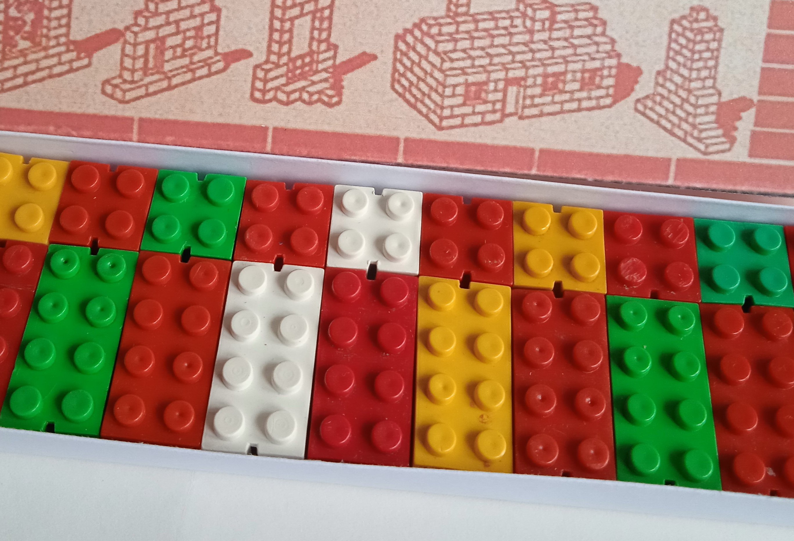 The image shows a box of colorful bricks arranged in a pattern