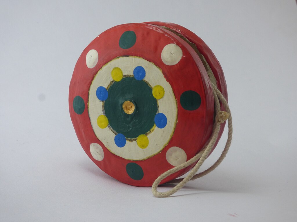 The image shows a colorful wooden yo-yo, string is attached to the center.