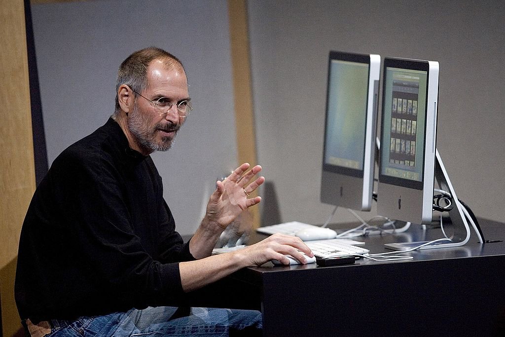 Apple CEO Steve Jobs uses a new iMac computer