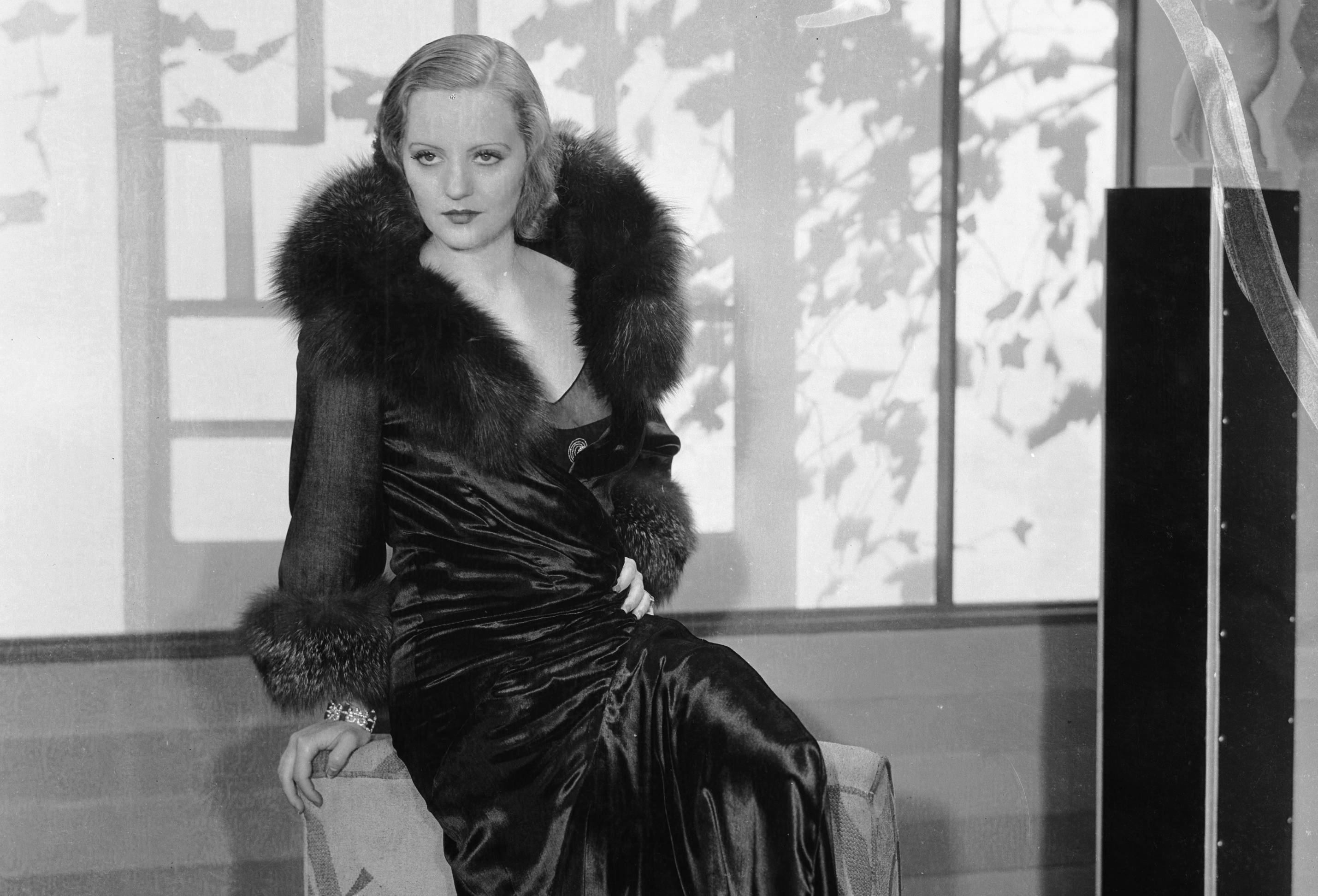 Tallulah Bankhead (1902 - 1968) wearing a silk robe with