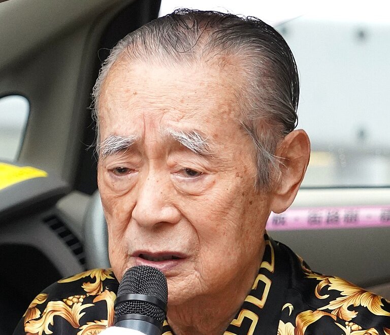 Yoshiro Nakamatsu holding a microphone