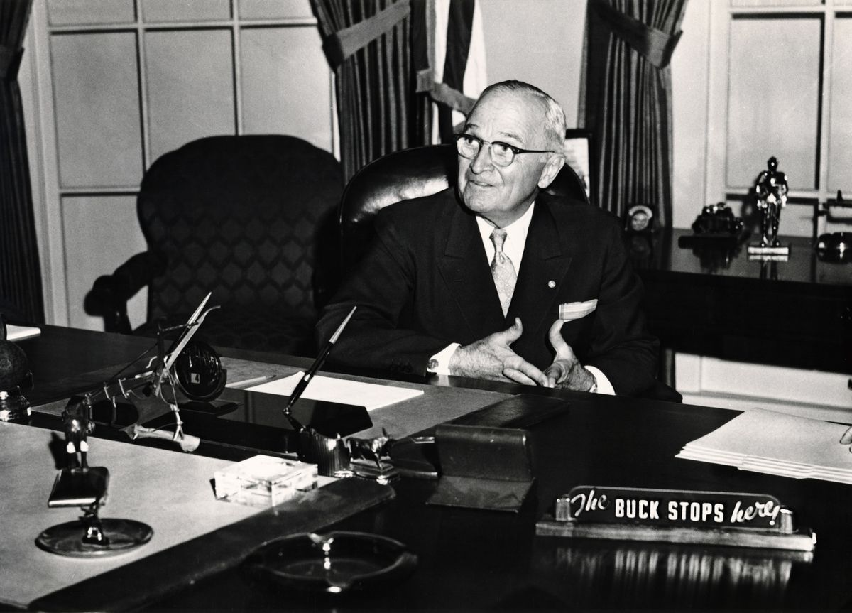 President Truman sits at a recreation of his Oval office at the Truman Library