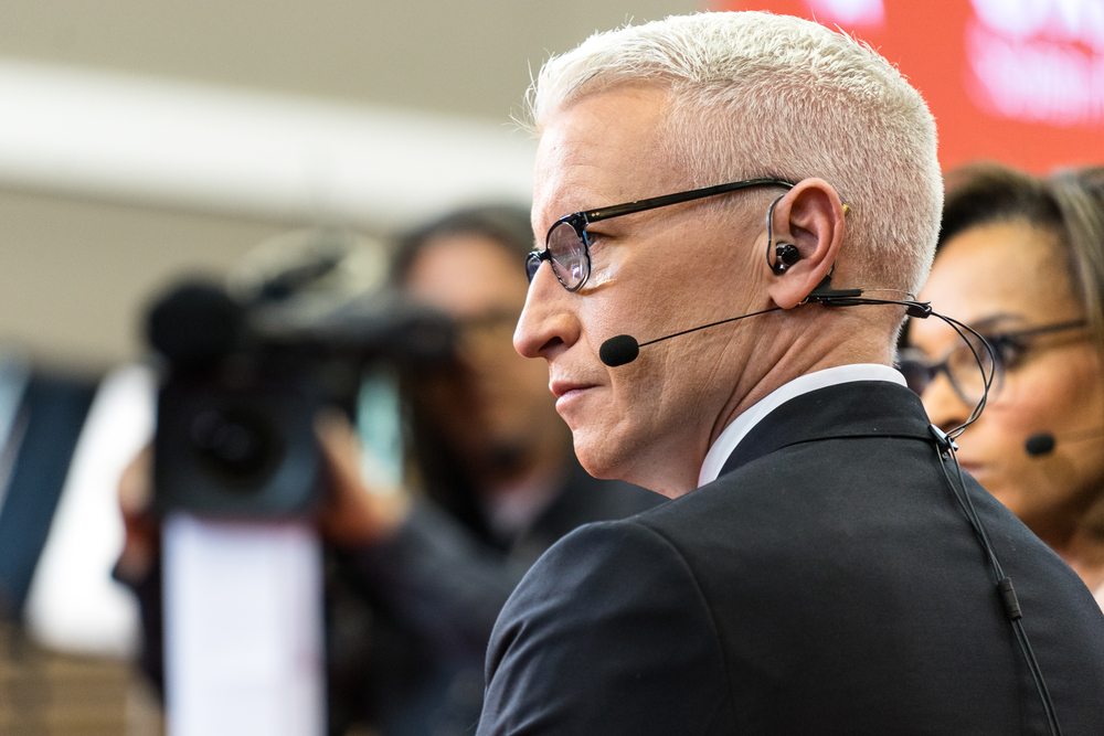 Anderson Cooper sits on the set