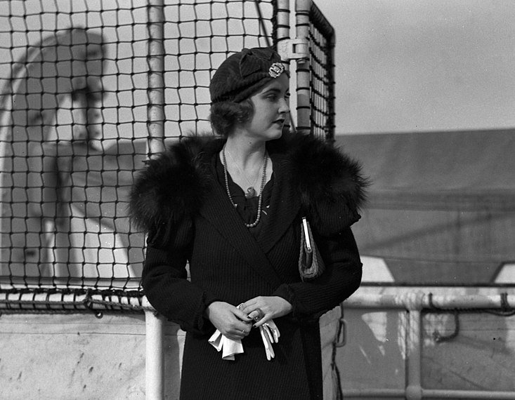 Barbara Hutton standing on a ship and looking to her left.