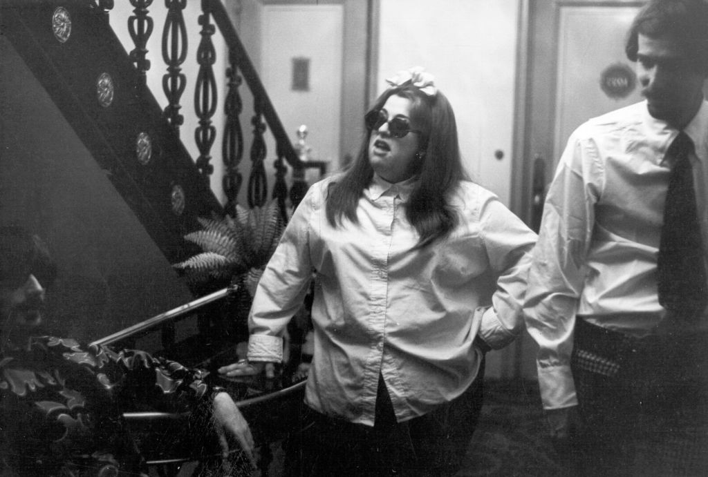 Cass Elliot in white shirt and glasses with band mates