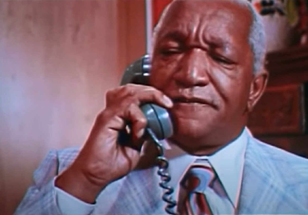 Screenshot of Redd Foxx talking on the blue telephone - from Norman... Is That You? (1976)