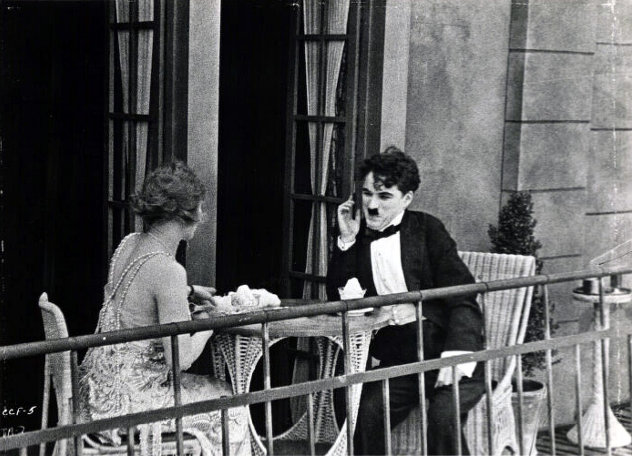 Edna Purviance (left) and Charlie Chaplin in The Adventurer