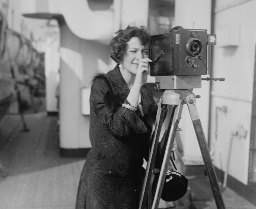 Fannie Brice in black dress looking trough a camera