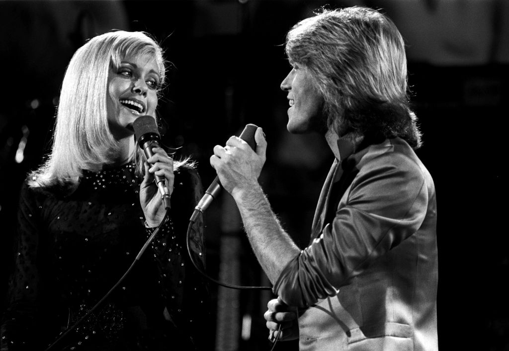 Olivia Newton-John and Andy Gibb perform on stage at Music for UNICEF
