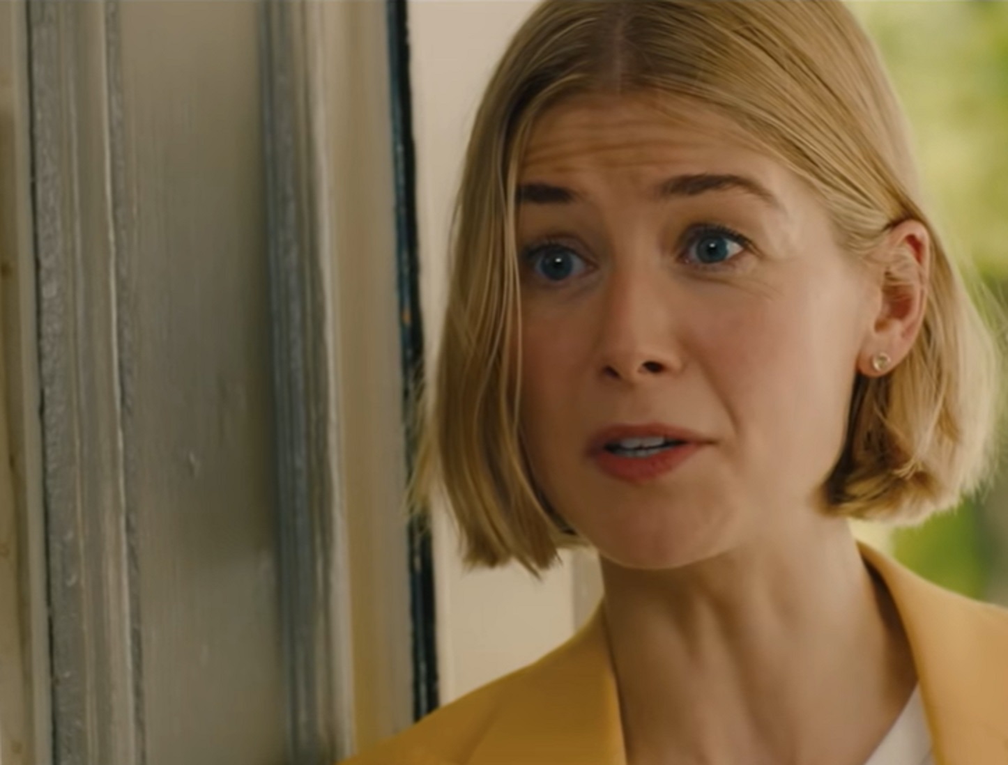 Screenshot of Marla Grayson in yellow jacket talking - from I Care a Lot (2020)