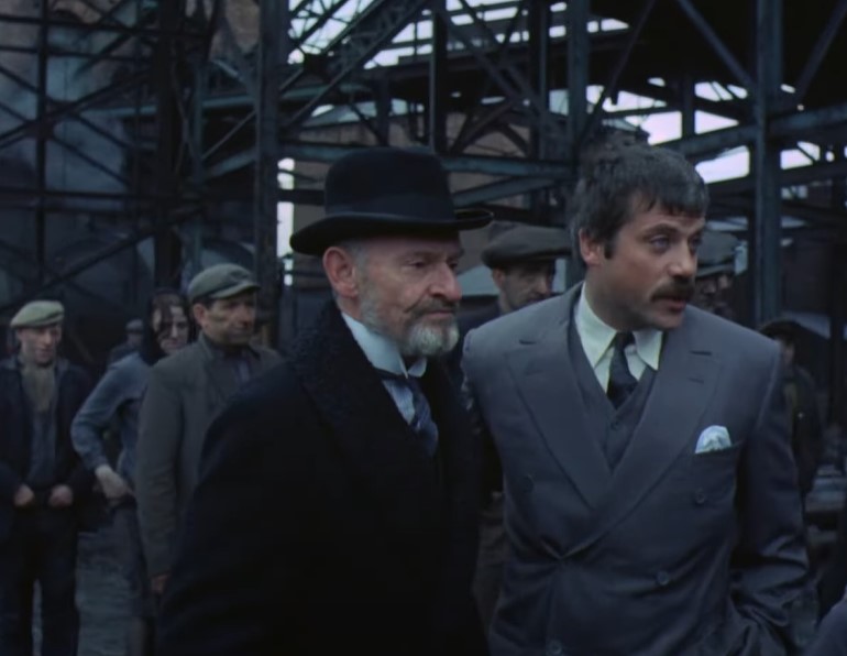 Oliver Reed in Women in Love wearing gray suit