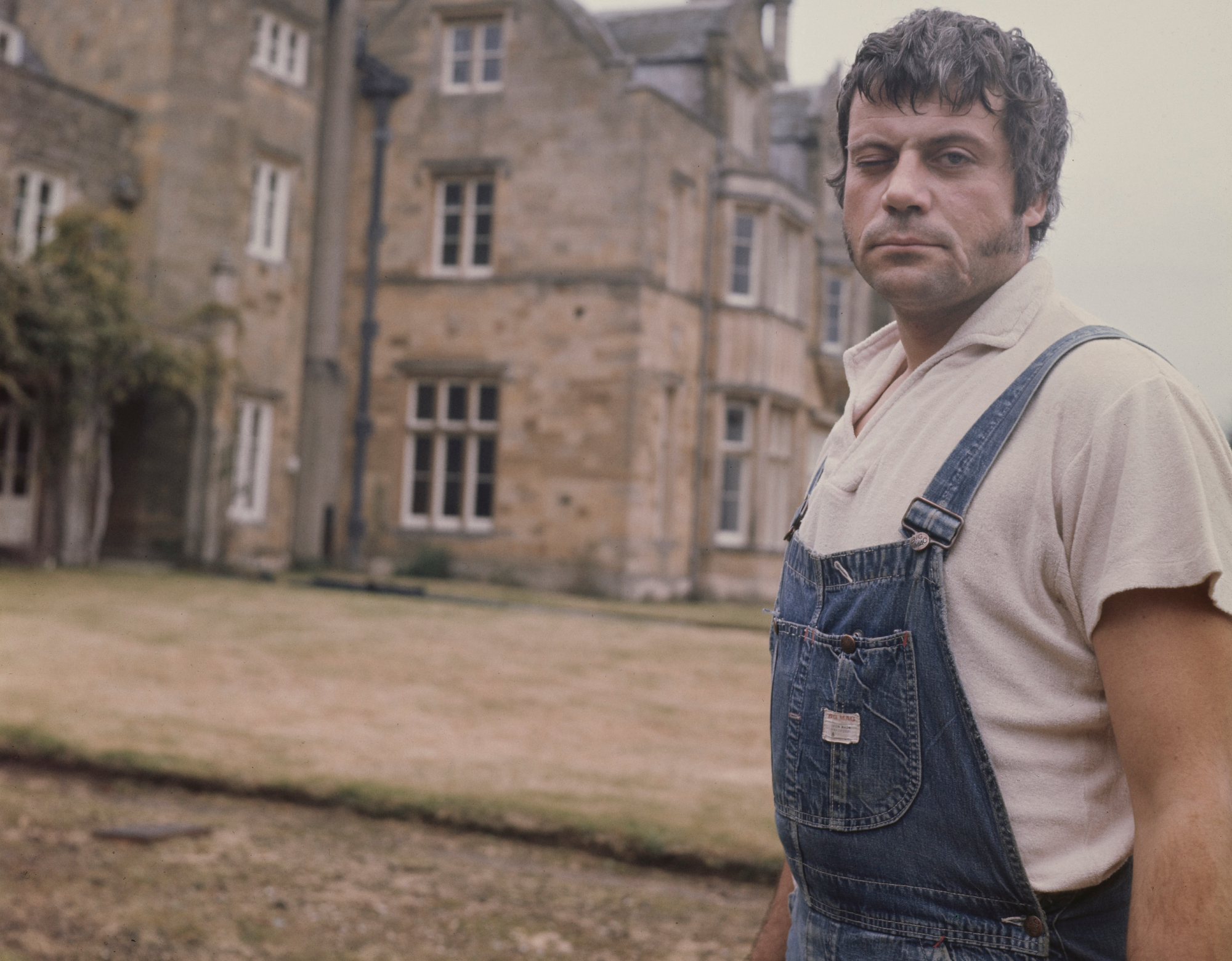 English actor Oliver Reed  outside mansion