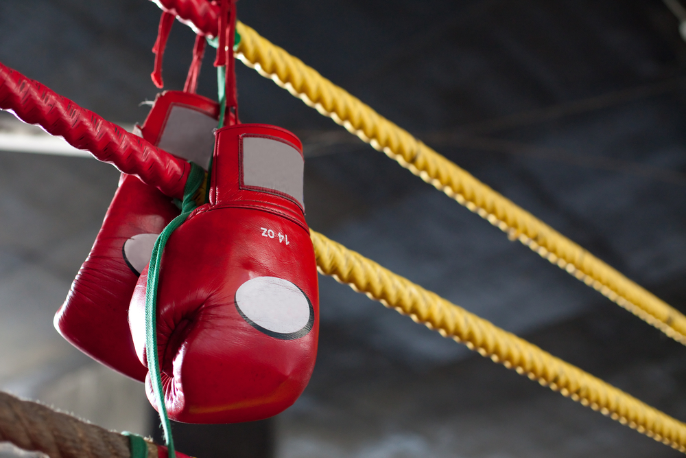 boxing gloves hangs off the boxing ring