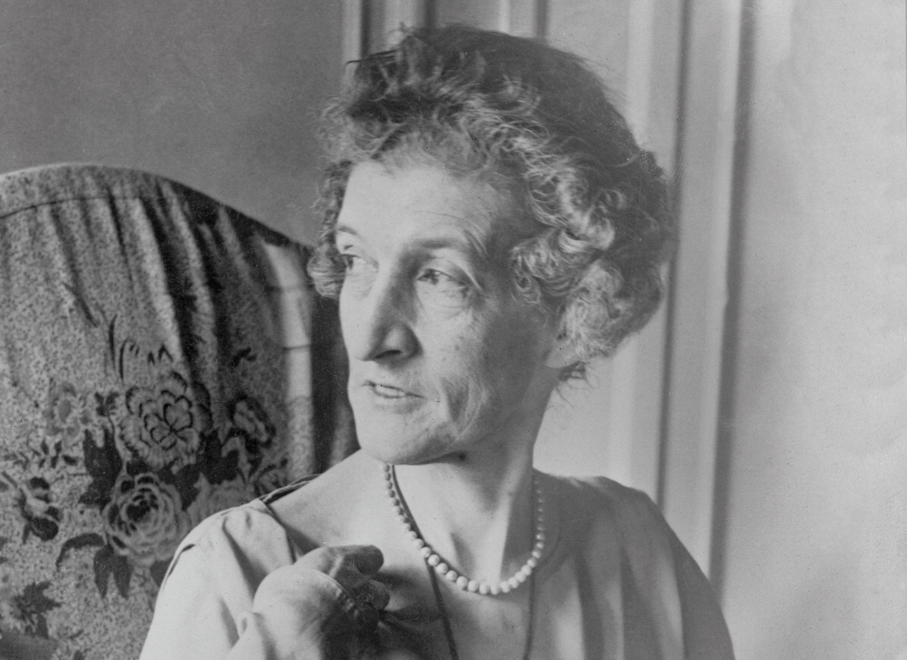 Margot Asquith in Chair wearing pearls and dress