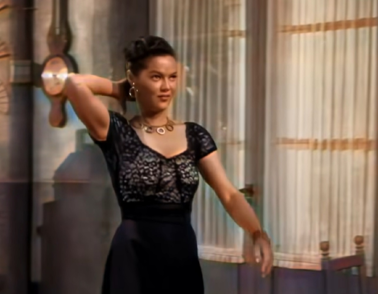 Screenshot of Dona Drake in black dress looking at side - from Kansas City Confidential (1952)