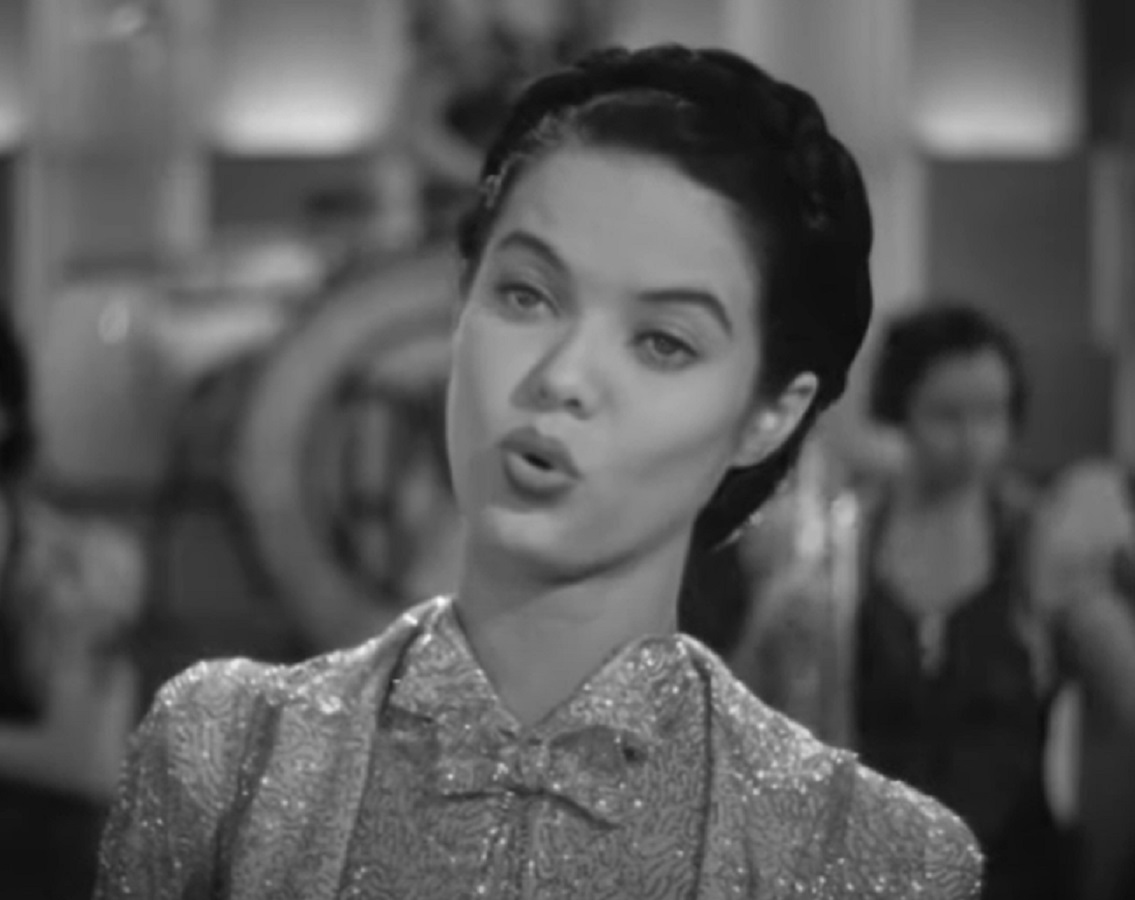 Screenshot of Dona Drake singing and looking at side - from Rita Rio and Her Orchestra (1939)