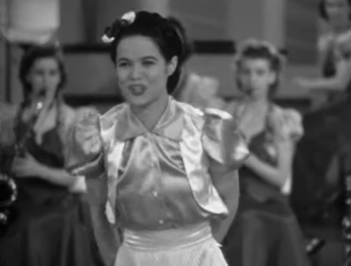 Screenshot of Dona Drake performing on stage - from Rita Rio and Her Orchestra (1939)