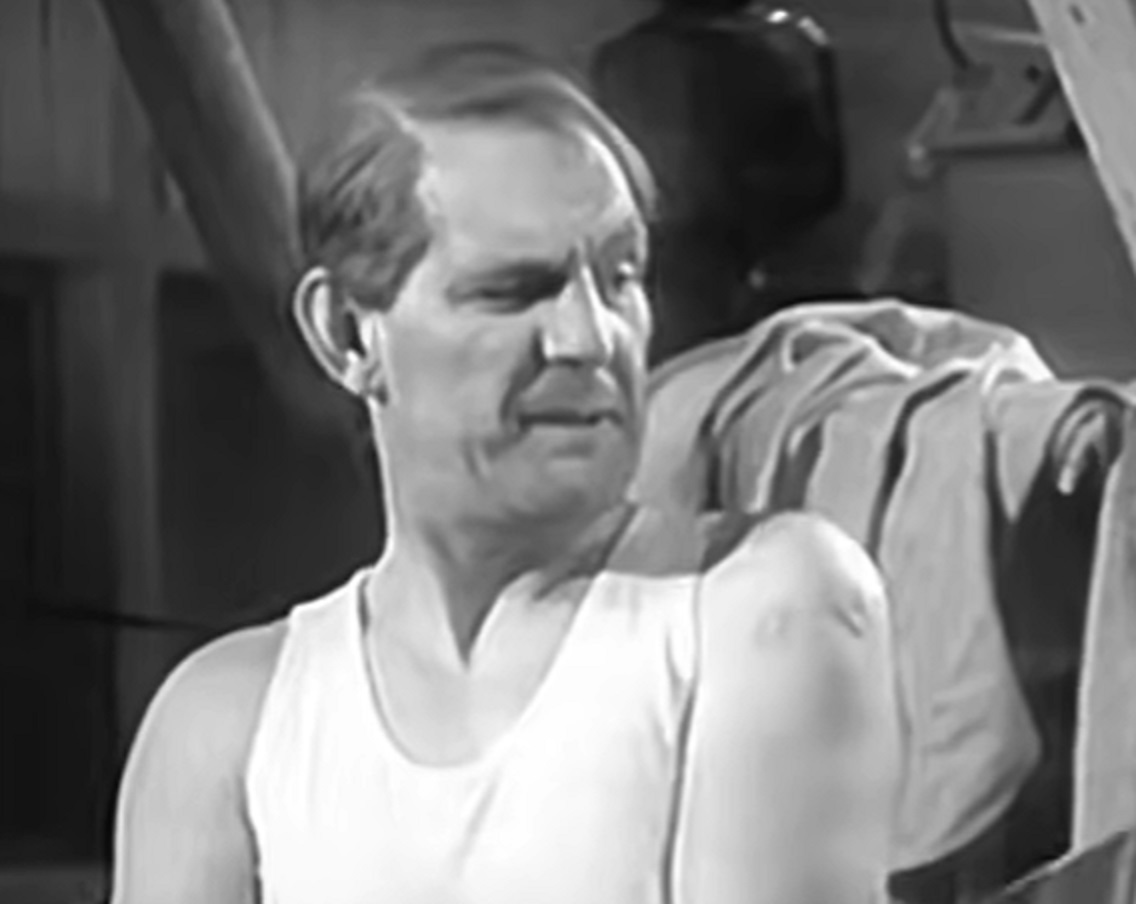 Screenshot of Will Hay in white shirt looking at side - from Where's That Fire? (1940)