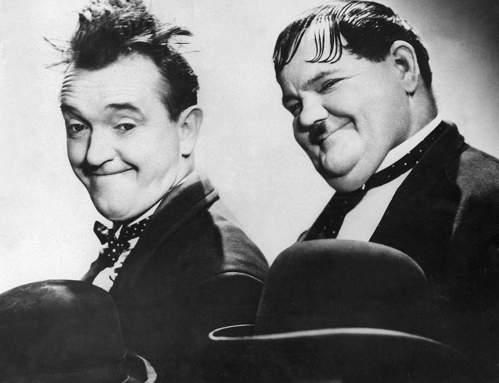 Stan Laurel and Oliver Hardy in Dick & Doof wearing black suits