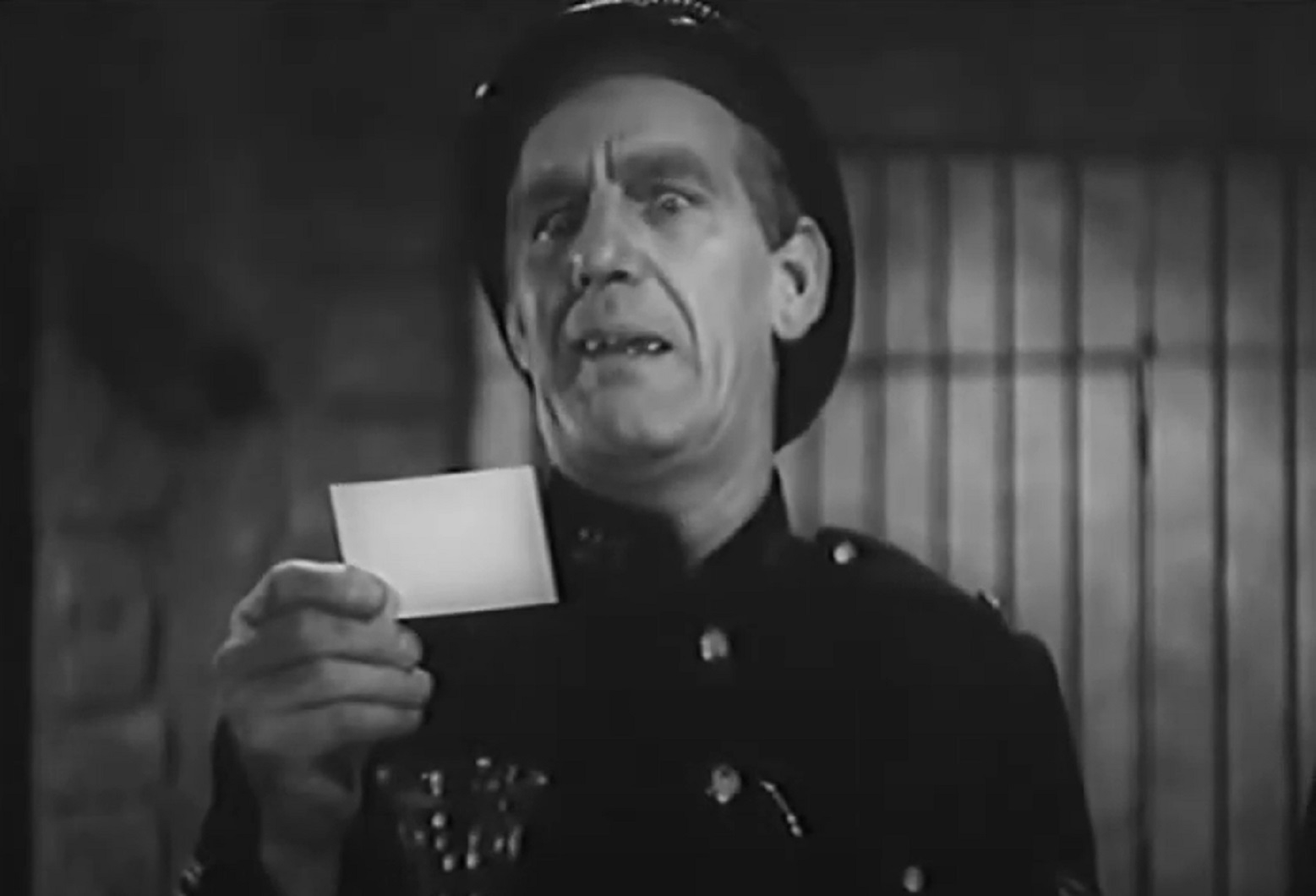 Screenshot of Will Hay reading a note - from Ask a Policeman (1939)