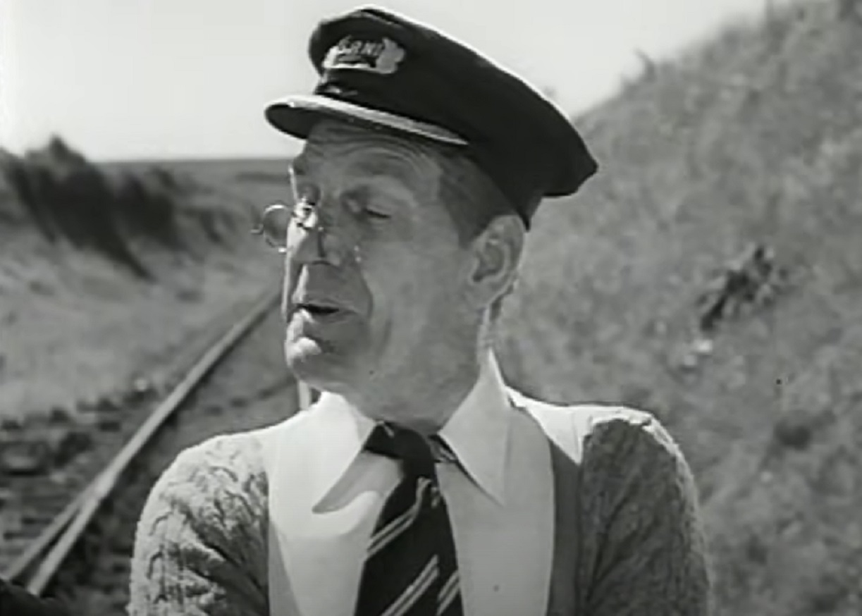 Screenshot of Will Hay with white shirt is standing outside - from Oh, Mr Porter! (1937)