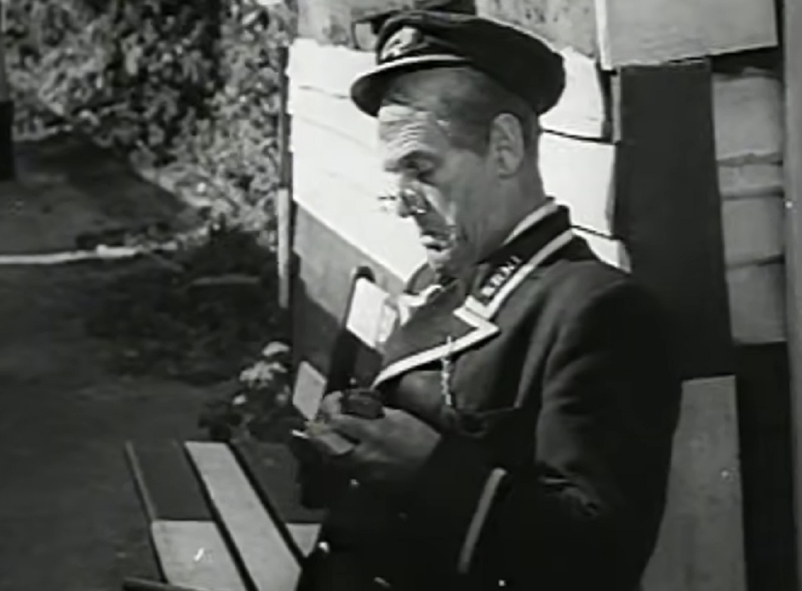 Screenshot of Will Hay seating on the bench outside - from Oh, Mr Porter! (1937)