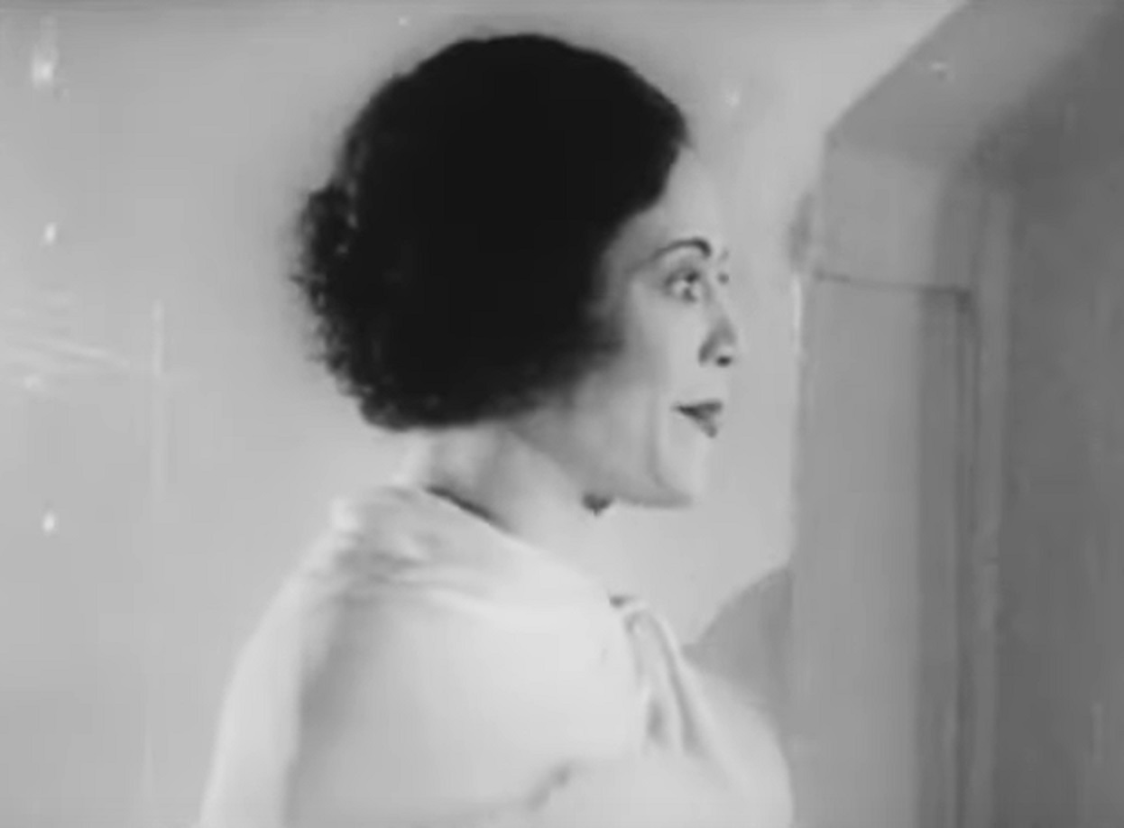 Screenshot of Fredi Washington looking at side in white dress - from Ouanga (1936)