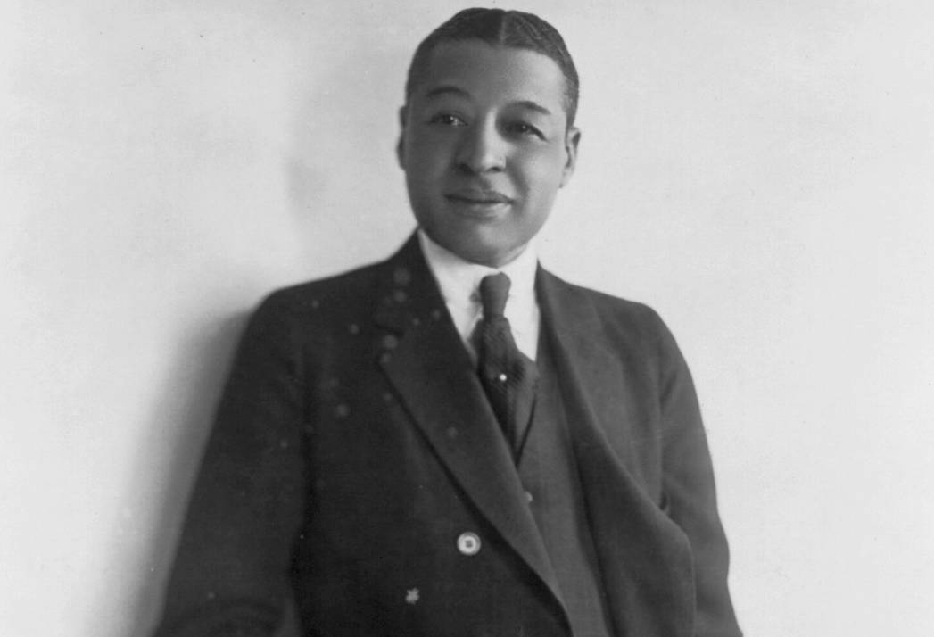 Photo portrait of Vaudeville star Bert Williams, seen standing