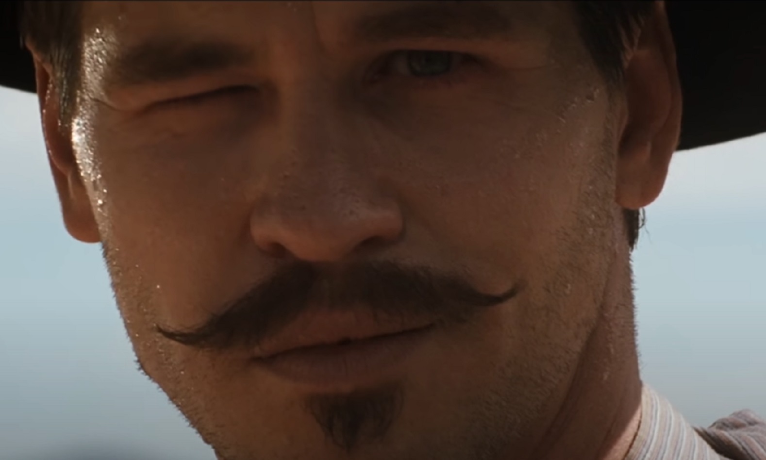 Screenshot of Val Kilmer winking and looking at front - from Tombstone (1993)