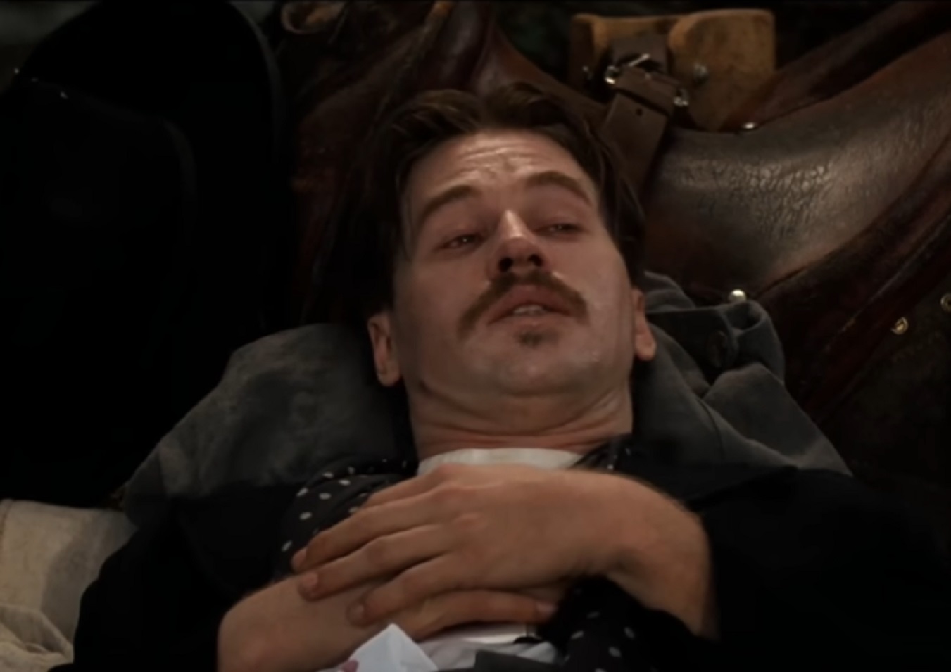 Screenshot of Val Kilmer laying on the bed - from Tombstone (1993)